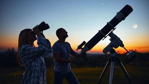 People observing through telescope and binoculars